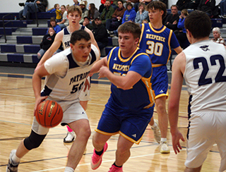 Connor Nuxoll drives toward the basket in the Patriots win against Nezperce. Also shown is fellow senior Tommy Rose. Photo by Steve Wherry.