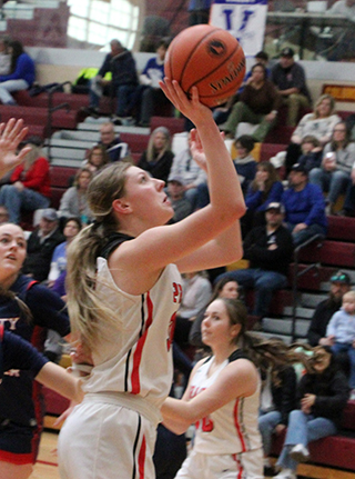 Kylie Schumacher scores on a lay-up against Liberty Charter. Also shown is Nadia Cash.