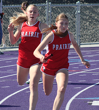 Mia Anderson hands off to Aubree Geis in the school record breaking 4x200.