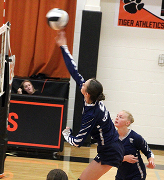 Catherine Beckman spikes the ball at Kendrick. Also shown is Madeline Wassmuth.