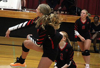 Beka Schumacher follows through on a spike against Lapwai. Also shown are Kylee Riggers and Mia Anderson.