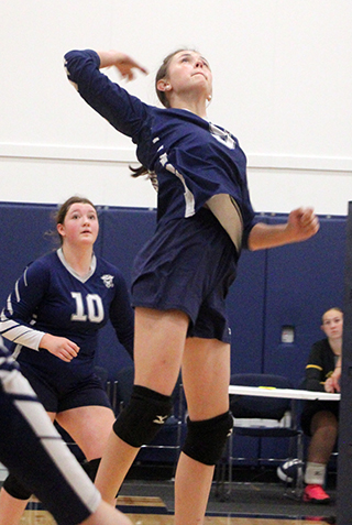 Catherine Beckman goes up for a spike during the tournament hosted by St. John Bosco on Saturday. Also shown is Miah Mager.