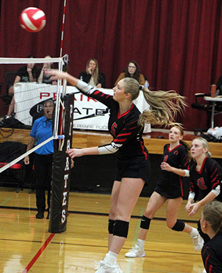 Beka Schumacher spikes the ball against Kamiah. Also shown are Kylee Riggers, Mia Anderson and Halee Rowland.