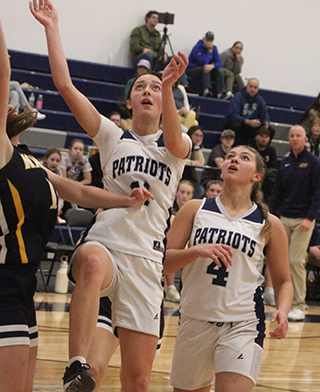 Savannah Perrin goes for a lay-up against Logos. Also shown is Teagen Dieseldorff.