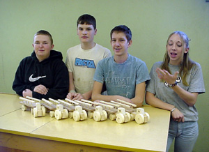 Ben Schumacher, Roscoe Arnzen, Tony Duman and Tabitha Sonnen with hay wagons they built for preschoolers.