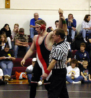 Alex Matson gets his hand raised in victory after winning the district championship.