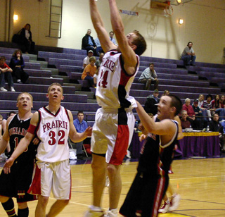 Jacob Riener goes high for a tip-in attempt at a missed shot. At left is Matt Baerlocher.