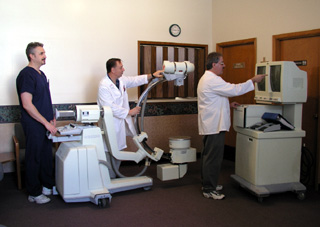 Ken Kreautler, Don Pitcher and Kevin Daly demonstrate the C-arm portable X-ray equipment recently purchased by St. Mary's Hospital and Clinics.  It has the capability to take 'live' digitized images.