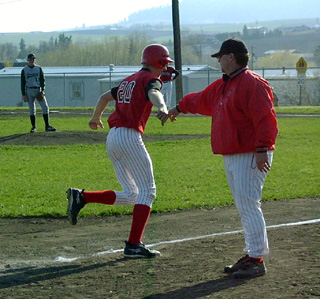 Chad Arnzen is congratulated by coach Pat Holthaus after hitting a homer for Prairie's first run.