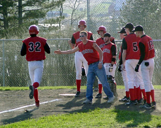 Tyler Crane is greeted by teammates at home plate after leading off the third inning with a homer.