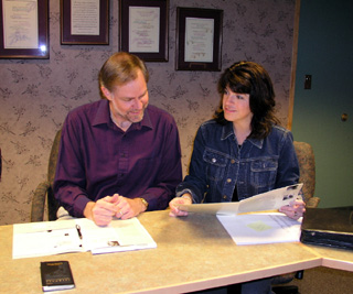 Larry Kidd and Casey Meza review materials prior to signing a contract with Blue Cross.