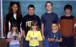Seventh graders gave Kindergartners potted bamboo plants. Both shared what they learned.