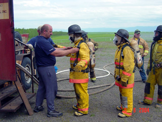 A safety check of firefighters before entering the burn trailer.