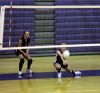 Natalie Arnzen digs a serve as Sarah Forsmann watches.