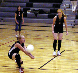 Lauren Merrill digs a serve as Natalie Arnzen watches.