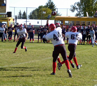 Kelby Wilson passes toward C.J. Rieman as Daniel Sigler, 65, blocks.