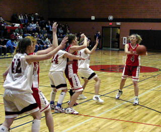 Bridget Enneking looks to pass the ball at Deary. Brittny Behler and Natalie Arnzen are in the high and low posts respectively.
