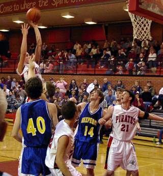 Seth Crane puts up a jump shot from near the free throw line. Corey Schaeffer and Kevin Funke set up for a rebound.