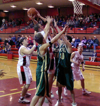 Seth Crane goes up in a crowd for a shot. J.D. Riener is at left and Kelby Wilson at right.