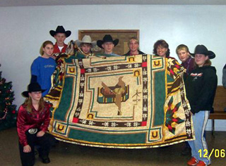 The rodeo team with the quilt they raffled off.