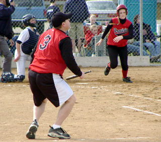 Steve Wilson and the New Plymouth catcher watch Kylie Uhlorn's homer head toward the fence as she heads for first.