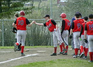 Phil Henry is the first to congratulate Chad Arnzen after his homer against Troy.