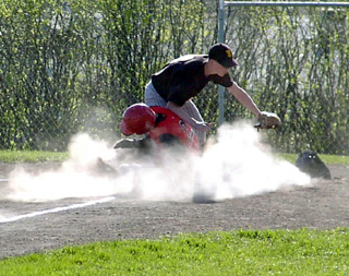 Mat Forsmann steals home and raises a cloud of dust as he scores.