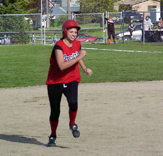 Carolyn Sonnen approaches third as in the background the Kendrick rightfielder has finally caught up to the ball.