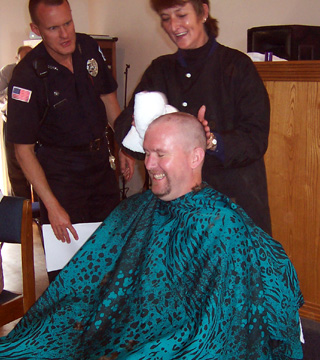 Warden Lynn Guyer gets his head shaved after NICI employees met a fundraising goal.