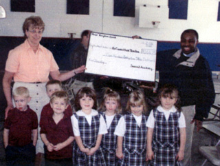 Summit preschoolers present a check to Fr. Temba.