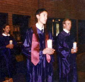The grads carry in candles during the Mass at St. Mary's prior to graduation.