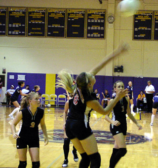 Bridget Enneking goes for a spike against Genesee. #2 is Lindsey Crea and #1 is Randi Schumacher.