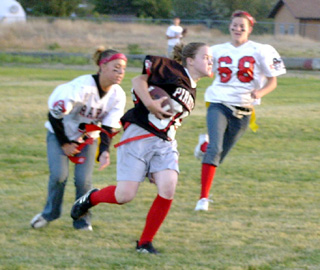 Ashley Jackson carries the ball as Tabitha Seubert, left, and Becky Gehring chase her.