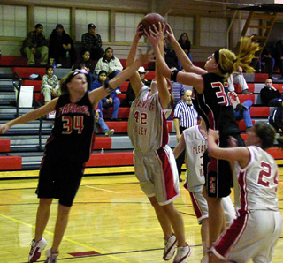 Natalie Arnzen and Brittny Behler battle C.V. for a rebound.
