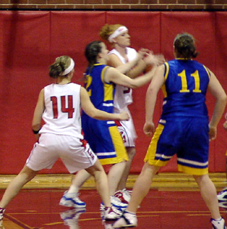 Natalie Arnzen grabs a rebound away from Nezperce. At left is Tabitha Sonnen.