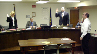 The newly elected council members take the oath of office. Standing from left are Shelli Schumacher, Max Nuxoll and Bill Hill.
