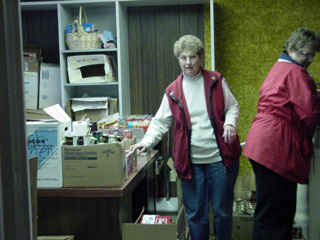 Irma Tacke and Merna Gehring stack food stocks in the new location.