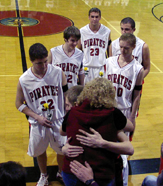 The senior basketball players presented yellow roses and had hugs for Lynn Rehder in honor of her son Jake, who would have been celebrating his senior night.