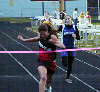 Nicole Nida breaks the tape as she wins the 400 meter dash.