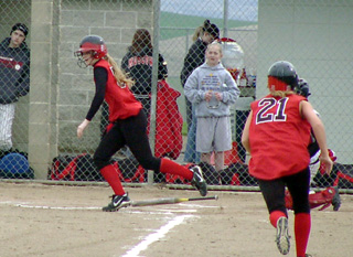 Kylie Uhlorn heads for first with an RBI single as Lindsey Crea scores from third.