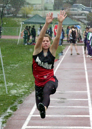 Kayla Uhlenkott flies through the snowflakes on her way to a second place finish in the triple jump.