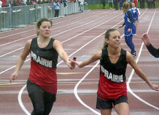 Kayla Uhlenkott hands off to Gina Holthaus in the 800 relay as Gina blinks away a snowflake.