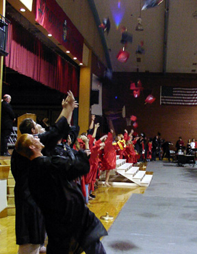 Grads toss their mortarboards at the end of the ceremony.