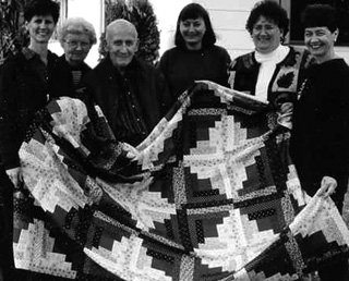 Bertha Kopczynski, second from left, joins her husband and daughters in proudly displaying a quilt the family made to memorialize Berthas daughter Carole after her death in 2001.