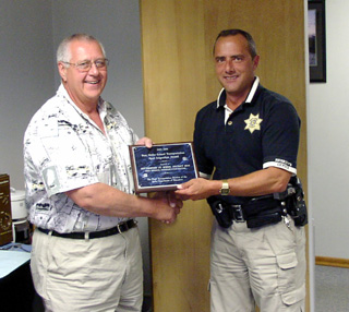 Dave Remacle, left, is presented his award by school board chairman John Nida.