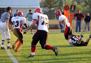 Danny Riener broke out of this attempted tackle and went on to score the game's first touchdown. At left are Jake Holthaus, 23, and J.D. Riener.