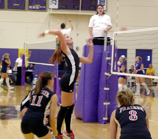 Sarah Arnzen goes high for a spike against Troy. Also shown are Alli Holthaus and Carolyn Sonnen.