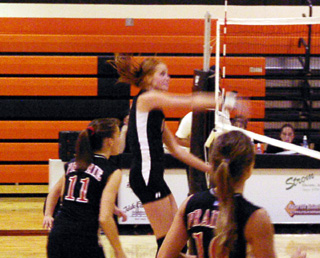 Sarah Arnzen follows through after a spike. Also shown are Alli Holthaus and Nicole Nida.