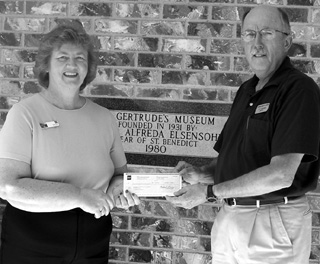 Wells Fargo Manager Joan Nuxoll presents Museum Director Lyle Wirtanen with a $1,000 check.