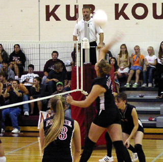 Tessica Nuxoll puts a big swing on the ball at Kamiah. Also shown are Kylie Uhlorn and Alli Holthaus.